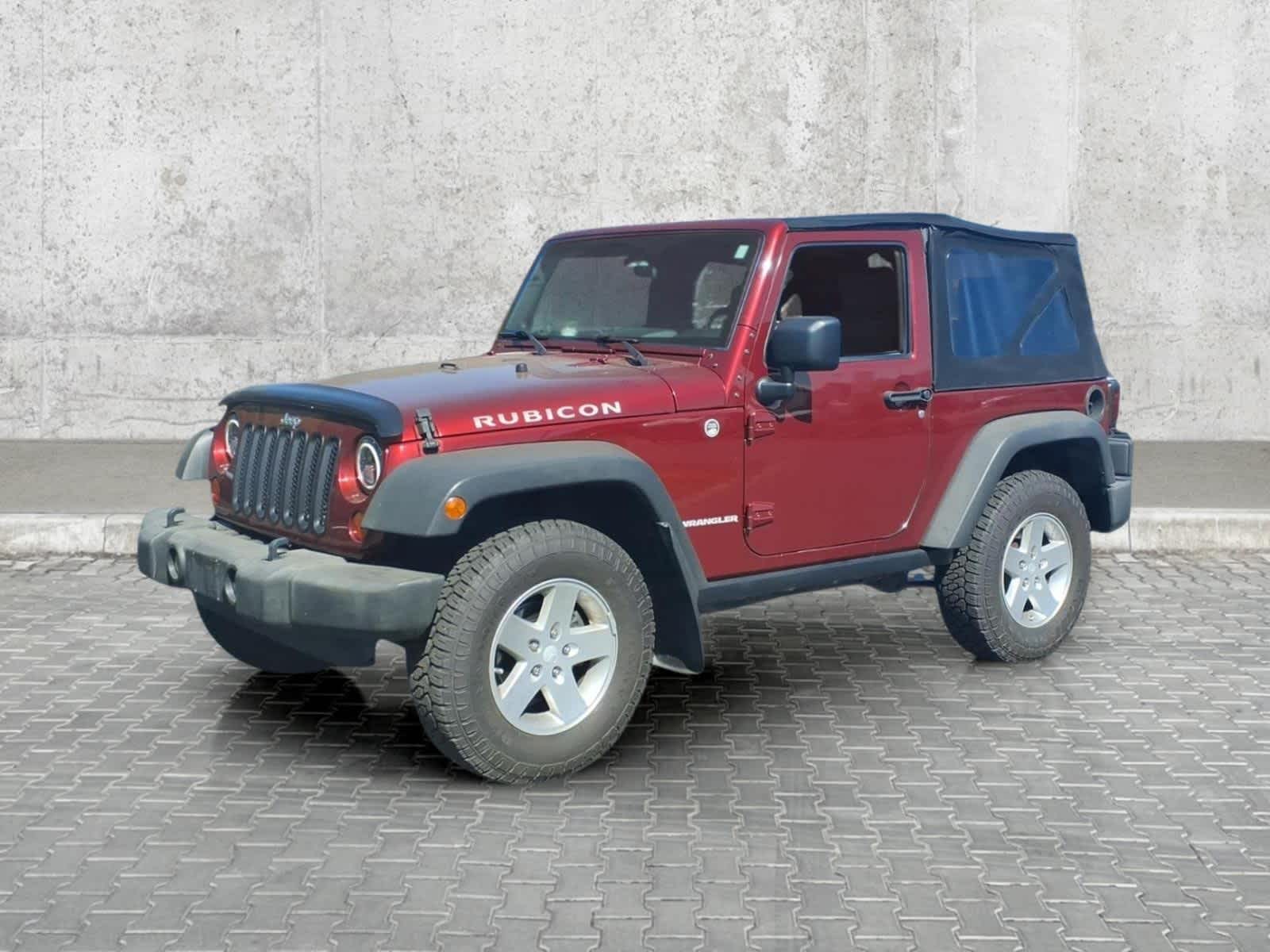 2009 Jeep Wrangler Rubicon in Red Rock Crystal Pearl — front three-quarter view